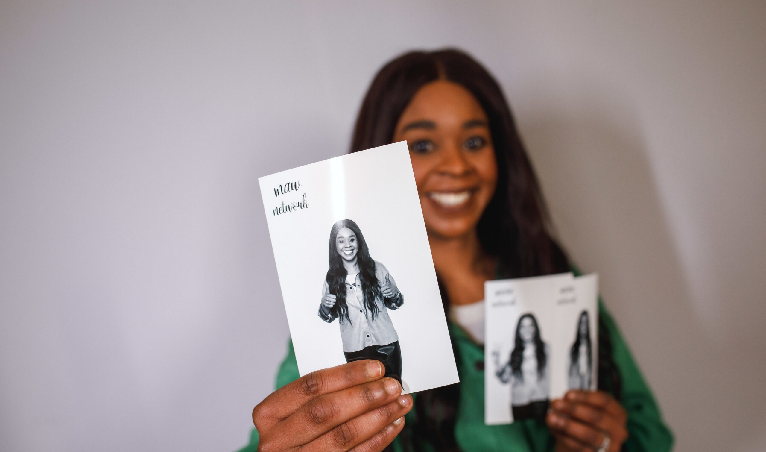 Guest smiling while holding her printed photo booth pictures