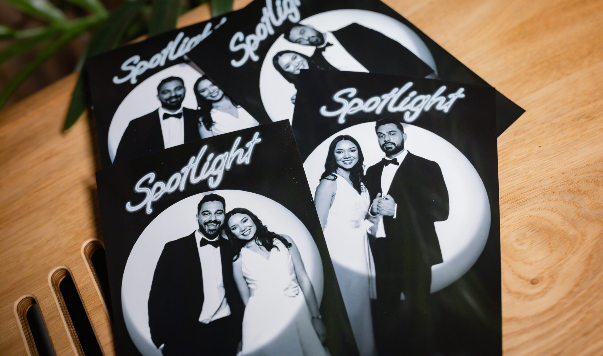 Spotlight branded photo prints arranged on a wooden table