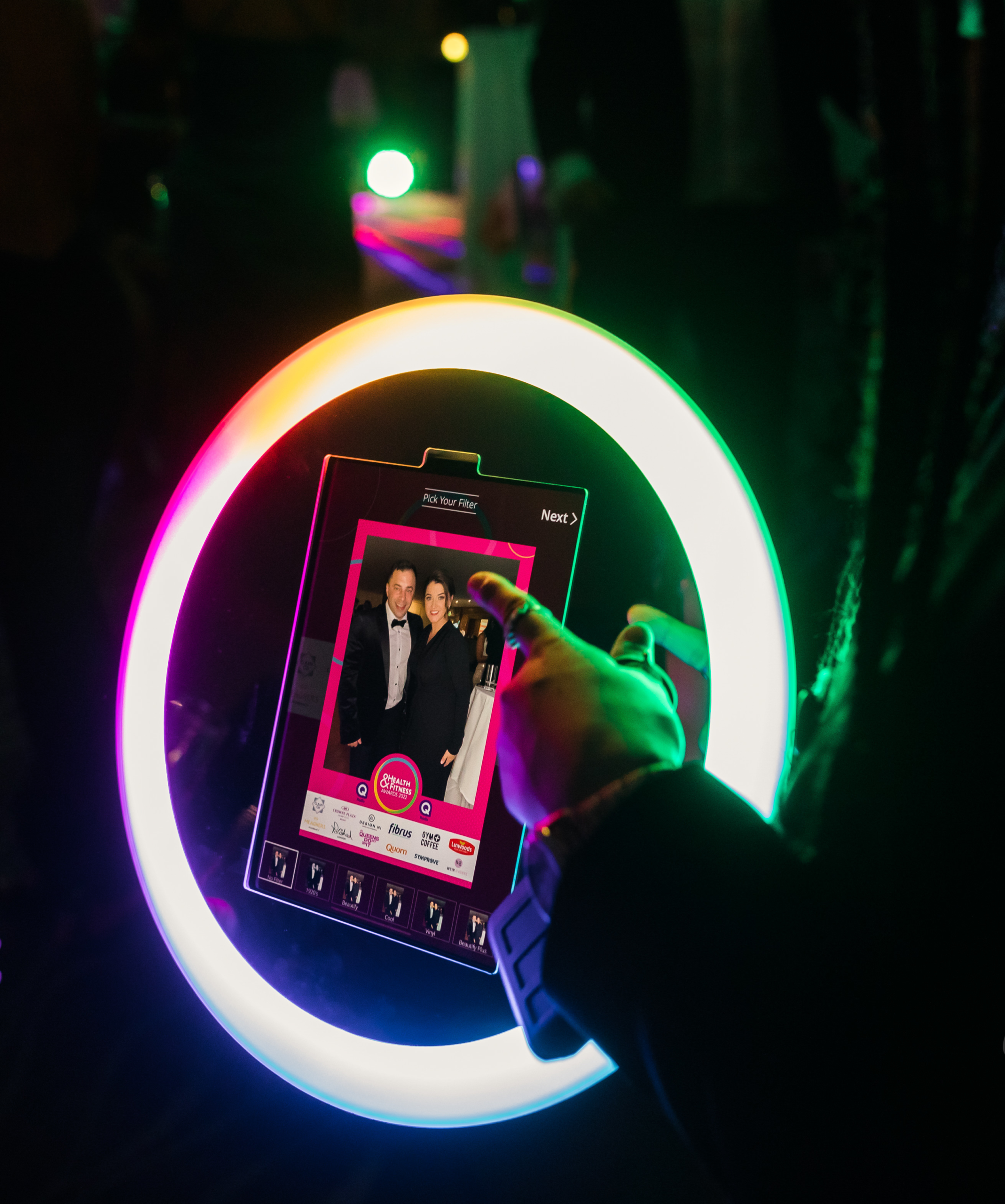 Glowing ring light photo booth capturing a guest at a night time event