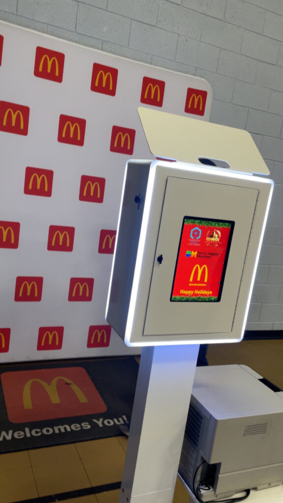 Photo booth with a red patterned backdrop at an activation