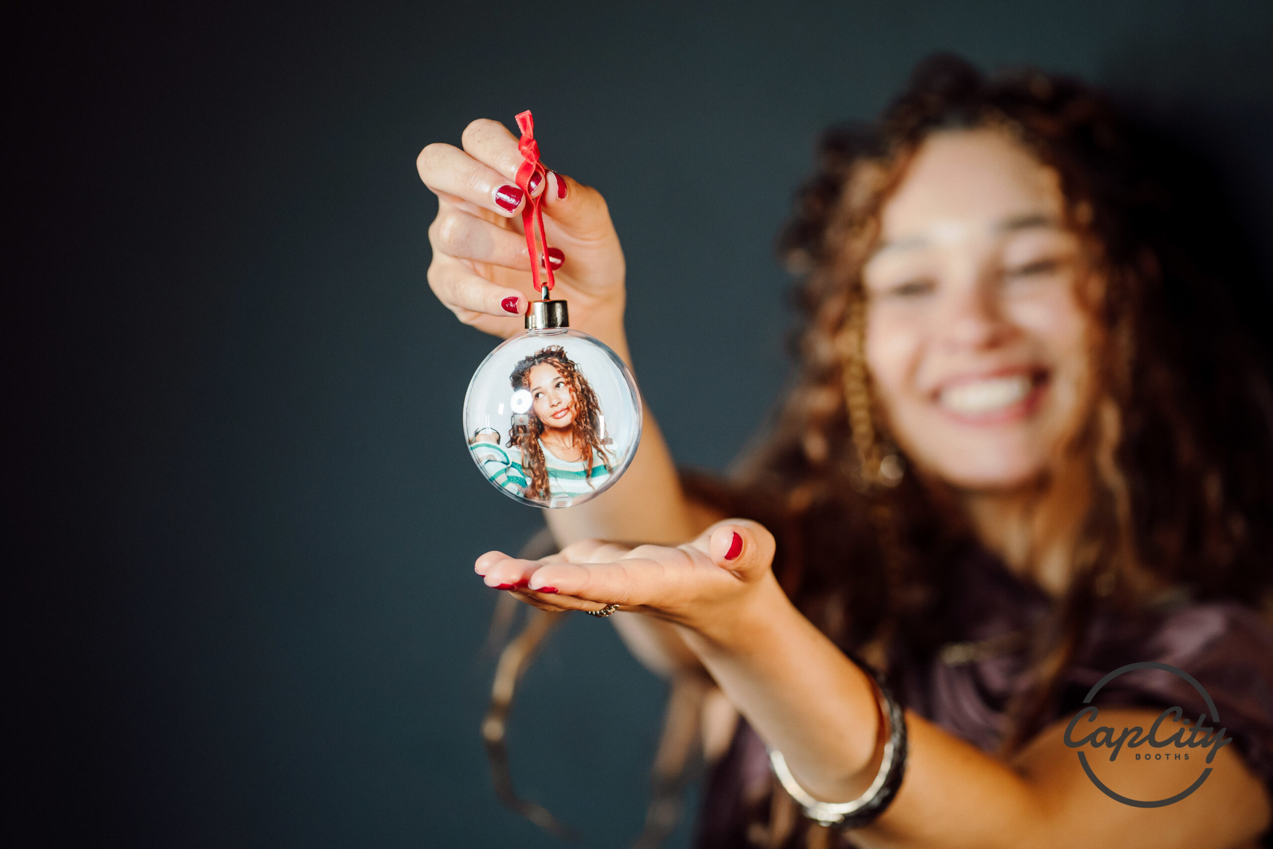 Guest holding a photo snow globe keepsake made at the booth